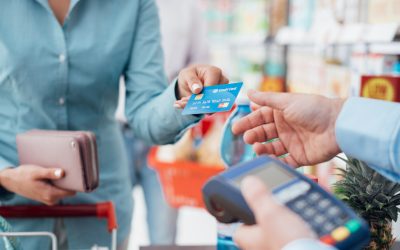 Woman at the supermarket checkout, she is paying using a credit card, shopping and retail concept